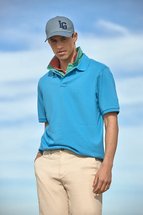 Hombre con polo piqué celeste de manga corta y gorra Legacy